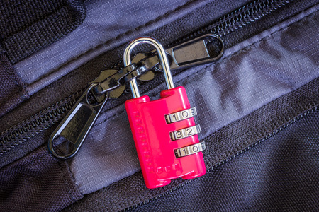 A padlock securing a suitcase